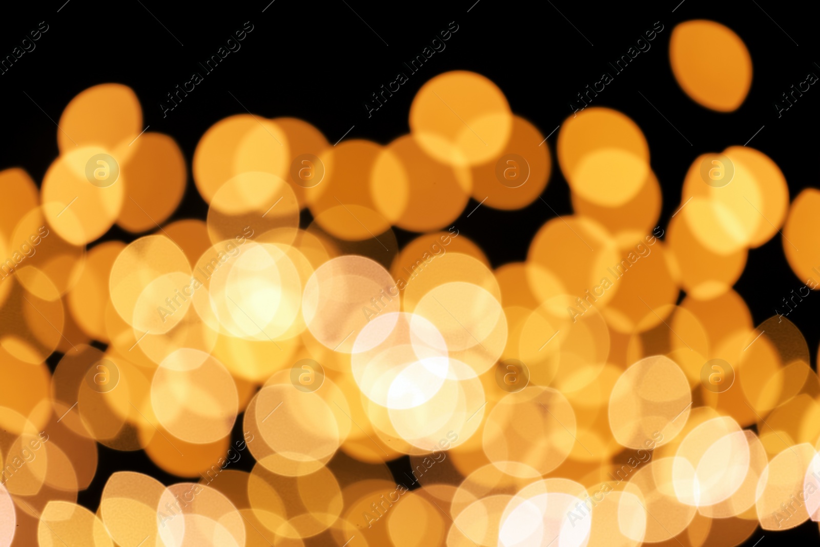 Photo of Beautiful golden lights on dark background. Bokeh effect