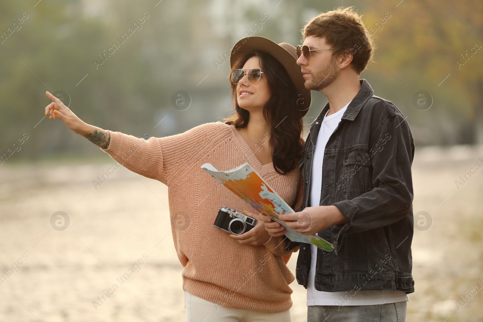 Photo of Couple of travelers with camera and map on city street