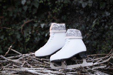 Photo of Snow falling on pair of ice skates outdoors