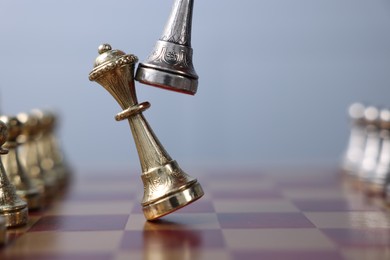 Chess pieces on checkerboard against grey background, closeup