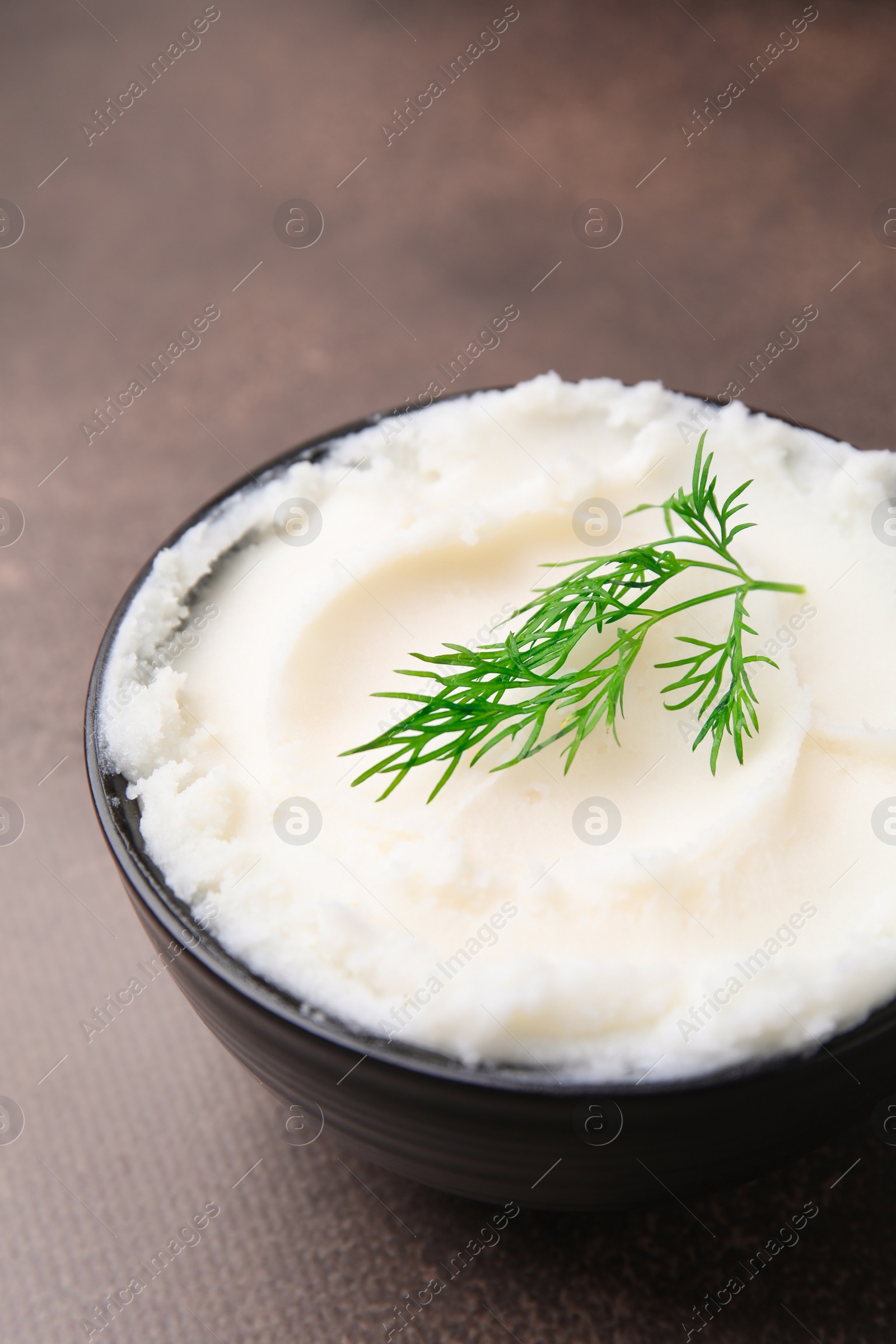 Photo of Delicious pork lard with dill in bowl on brown table