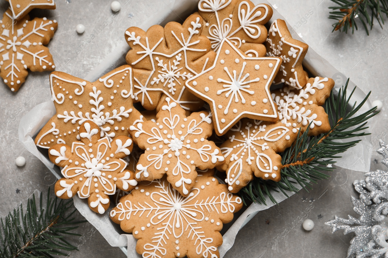 Photo of Tasty Christmas cookies and festive decor on light grey table, flat lay