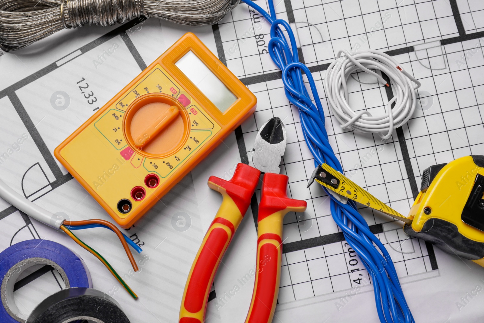 Photo of Different wires and tools on electrical schemes, top view