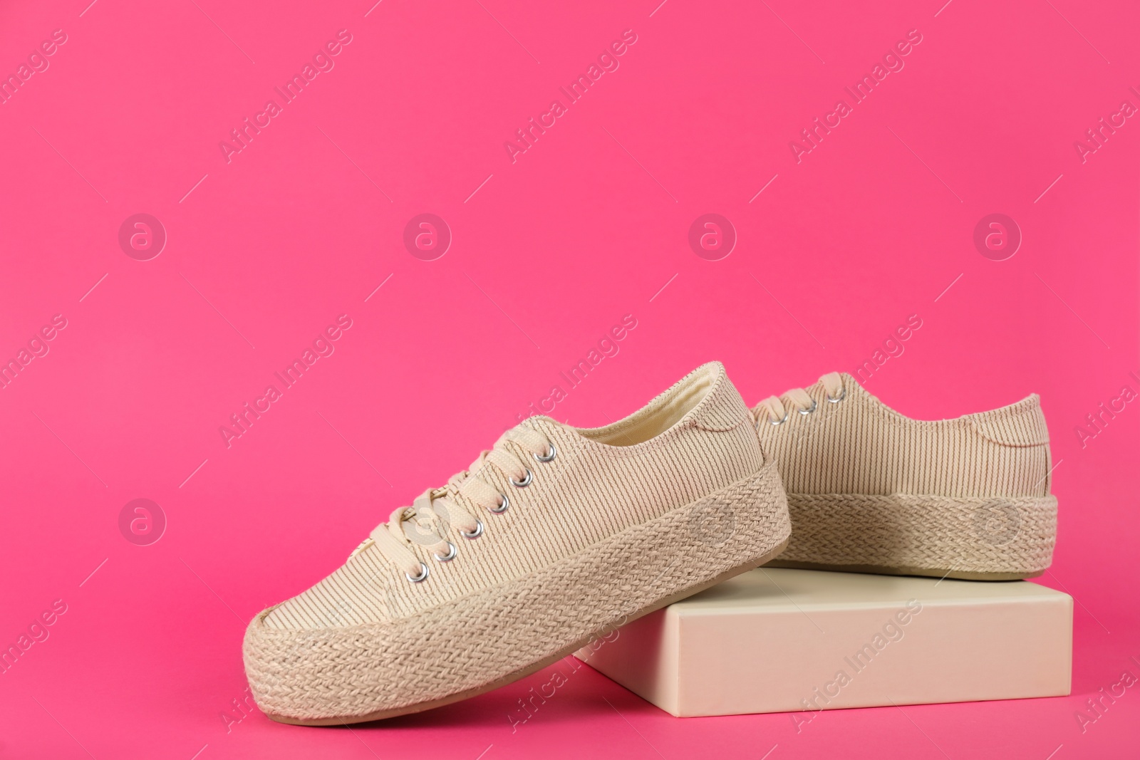 Photo of Pair of stylish sneakers on pink background. Space for text