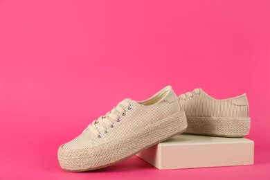 Pair of stylish sneakers on pink background. Space for text