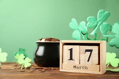 Composition with block calendar on wooden table, space for text. St. Patrick's Day celebration