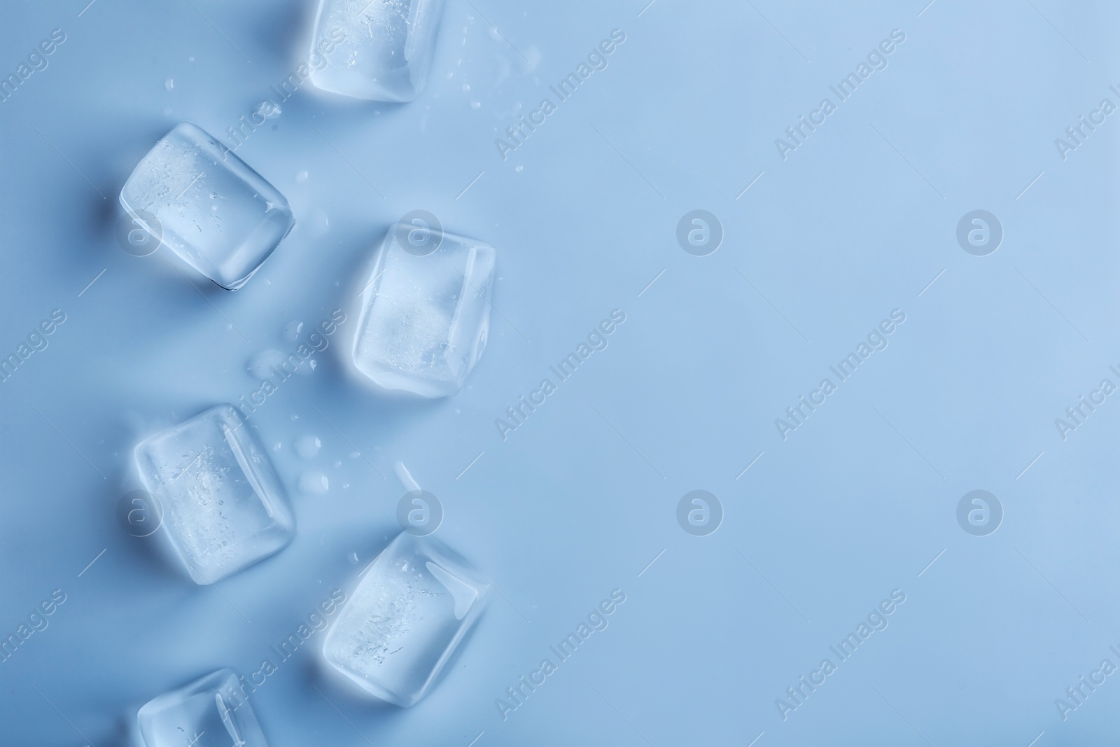 Photo of Ice cubes on color background, top view. Space for text