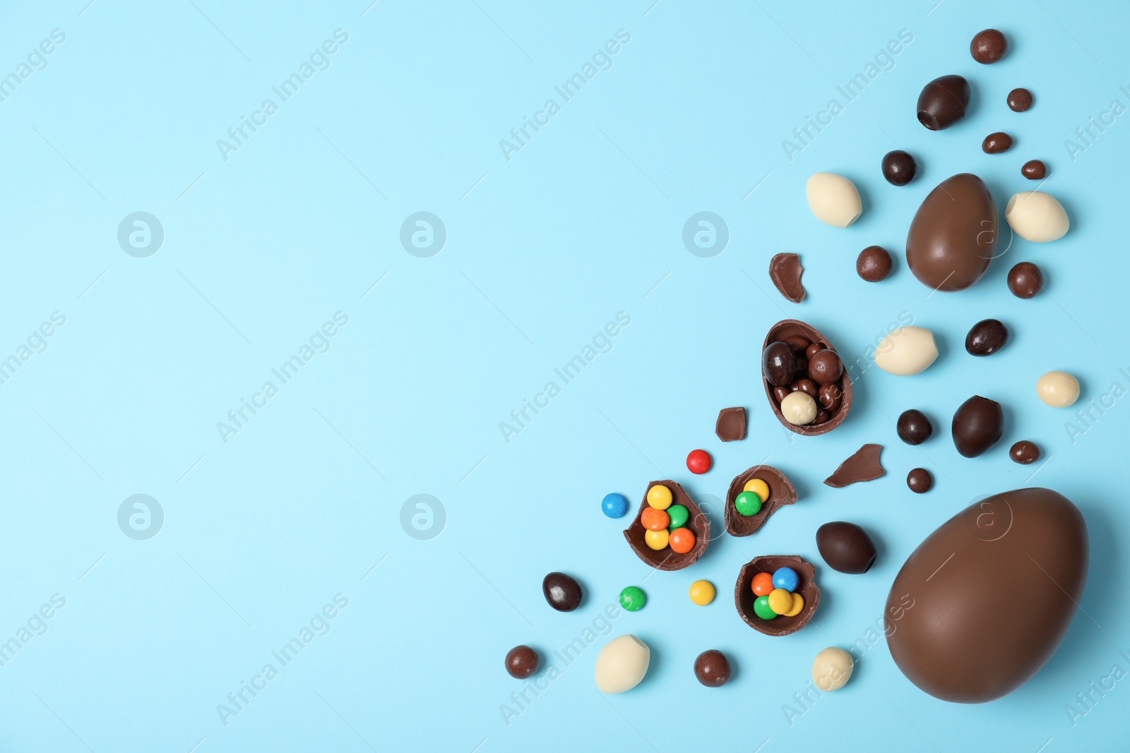 Photo of Flat lay composition with chocolate Easter eggs and space for text on color background