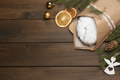 Photo of Wrapped Christmas Stollen with decoration on wooden table, flat lay. Space for text