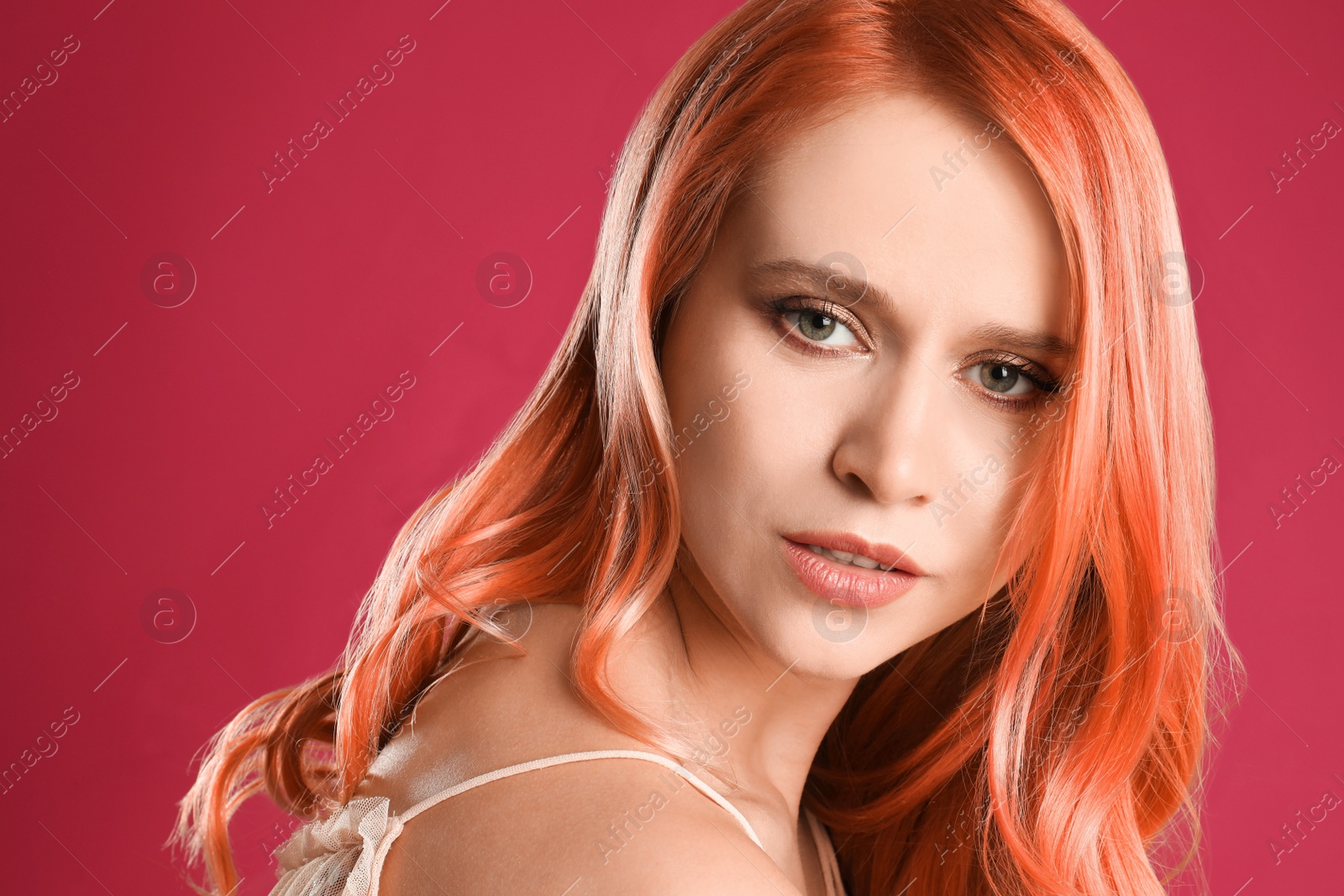 Image of Beautiful woman with long orange hair on pink background
