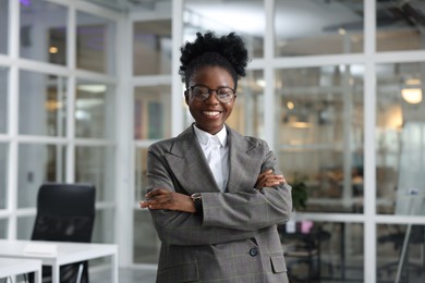 Photo of Happy woman with crossed arms in office. Lawyer, businesswoman, accountant or manager