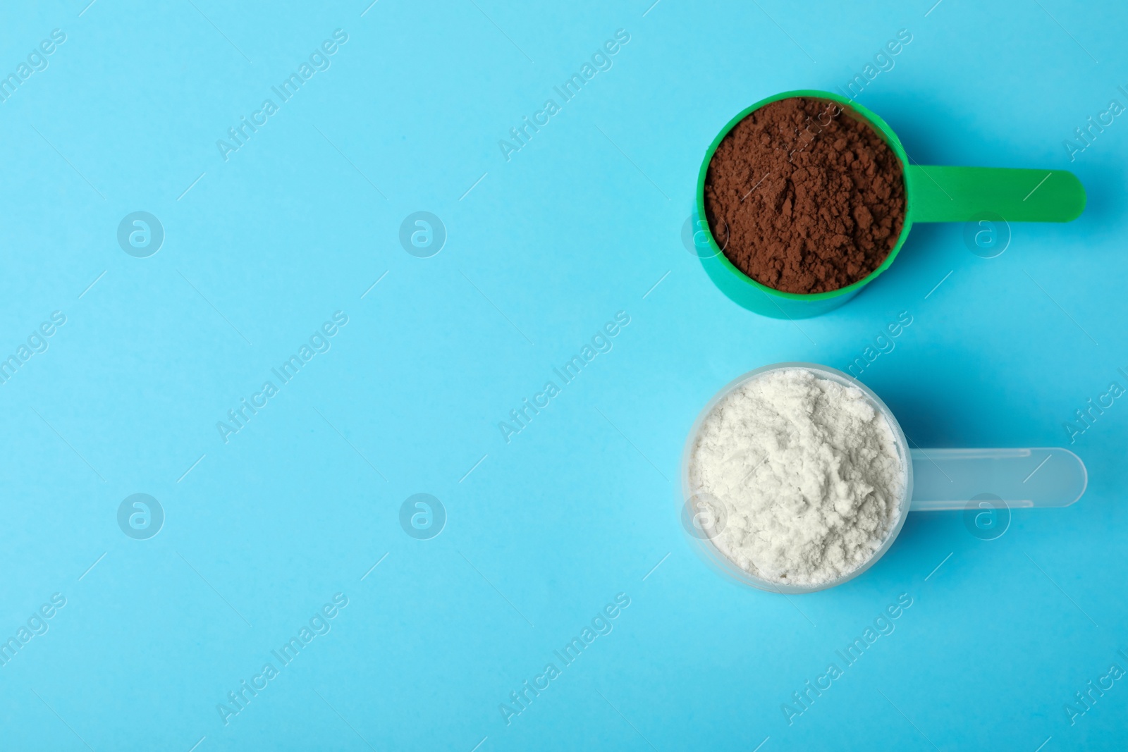 Photo of Scoops of different protein powders on light blue background, flat lay with space for text