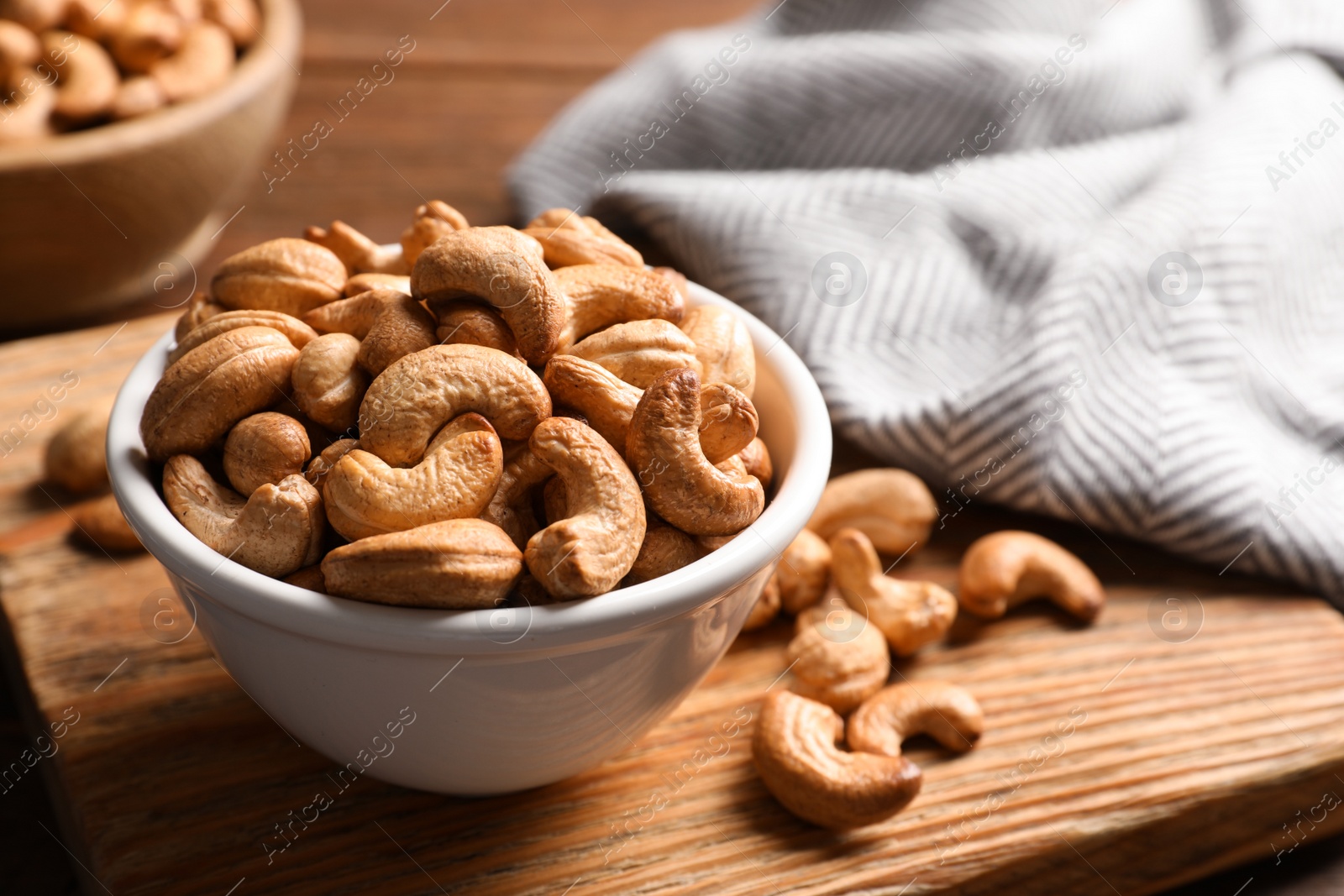 Photo of Tasty cashew nuts in bowl on table