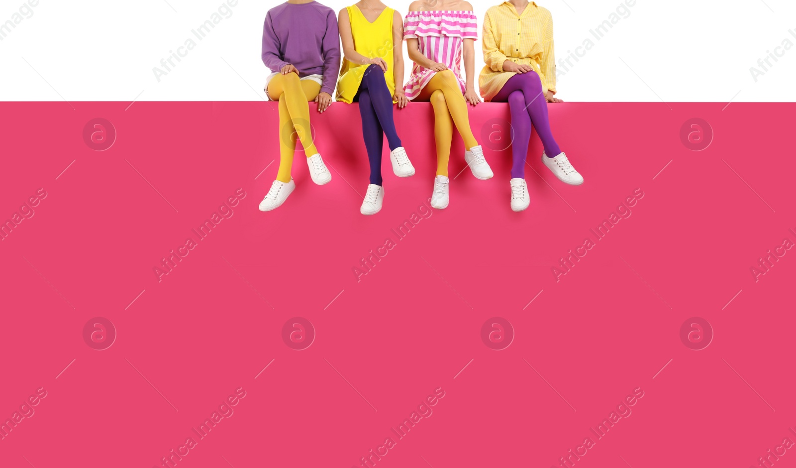 Photo of Group of women wearing bright tights and stylish shoes sitting on color background, closeup