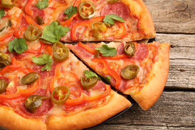 Photo of Delicious pizza Diablo on wooden table, closeup