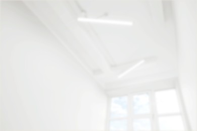 Image of Empty room with white walls and window, blurred view