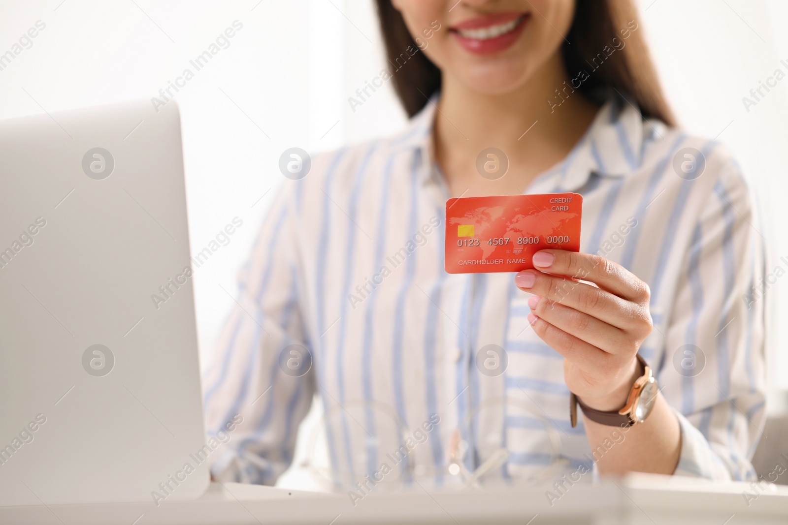 Photo of Woman with credit card using laptop for online shopping, closeup