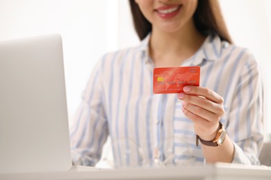 Photo of Woman with credit card using laptop for online shopping, closeup