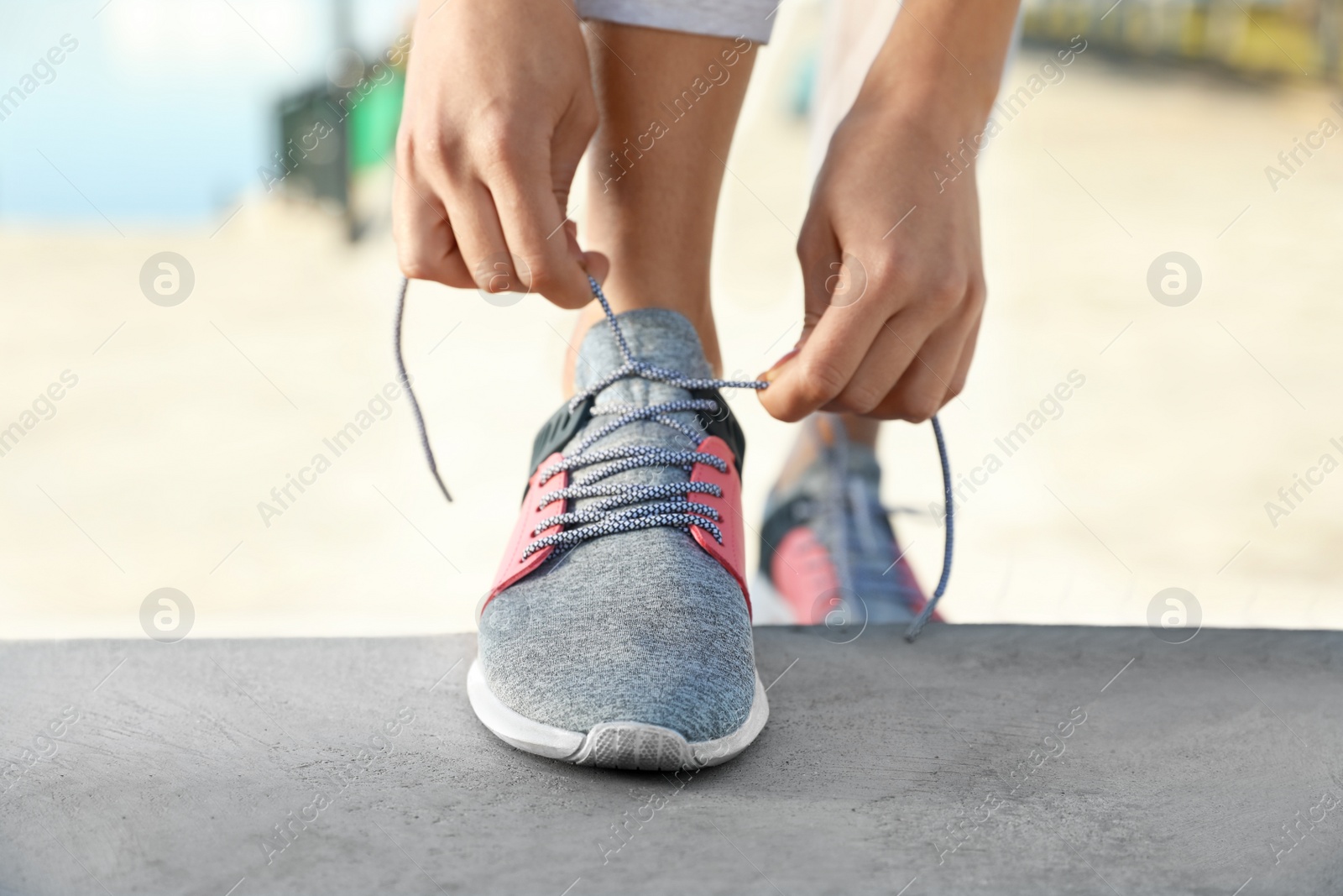 Photo of Sporty woman tying shoelaces before running outdoors