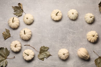 Photo of Flat lay composition with ripe white pumpkins on light grey table. Space for text