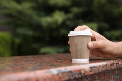 Photo of Man with takeaway coffee cup outdoors, closeup. Space for text