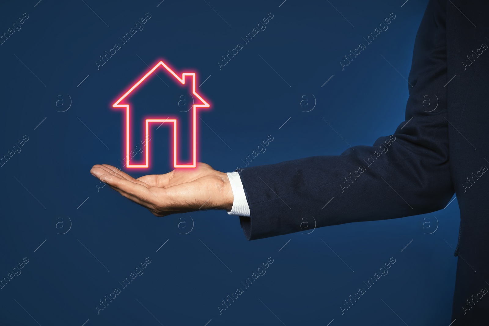Image of Mortgage rate. Man holding illustration of house on dark blue background, closeup