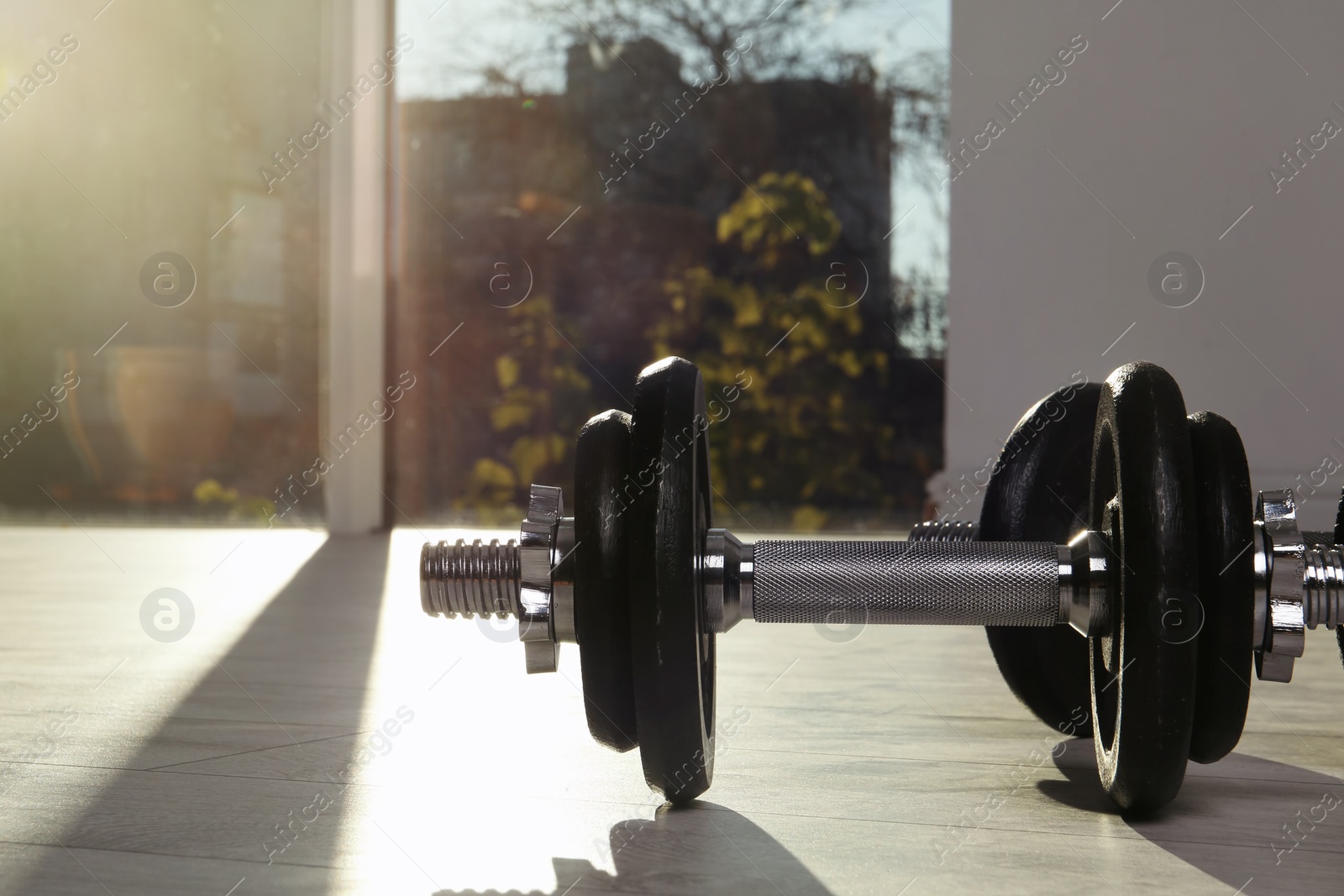 Photo of Pair of adjustable dumbbells on floor indoors. Space for text