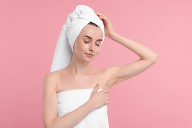 Beautiful woman showing armpit with smooth clean skin on pink background