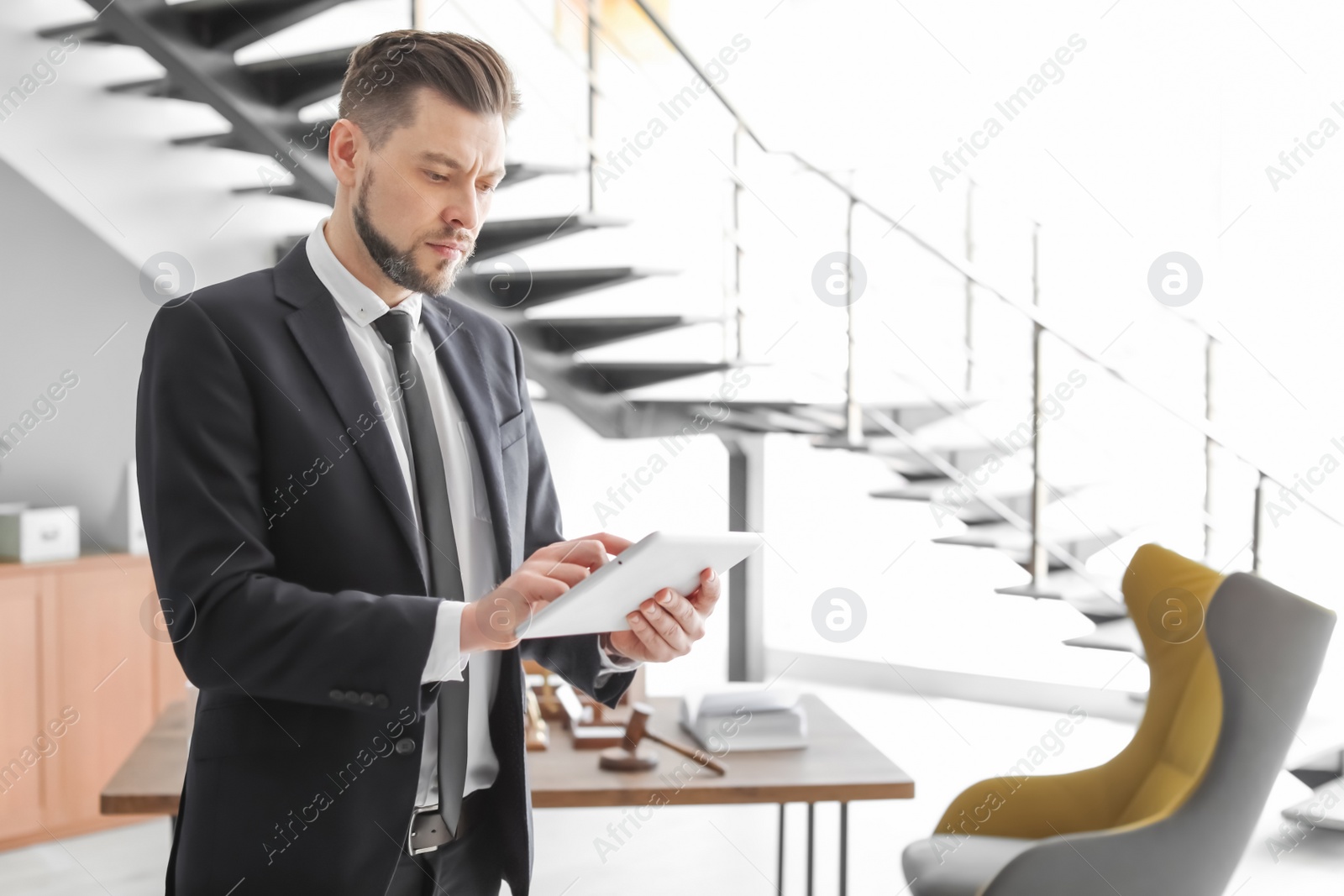 Photo of Male lawyer working with tablet in office