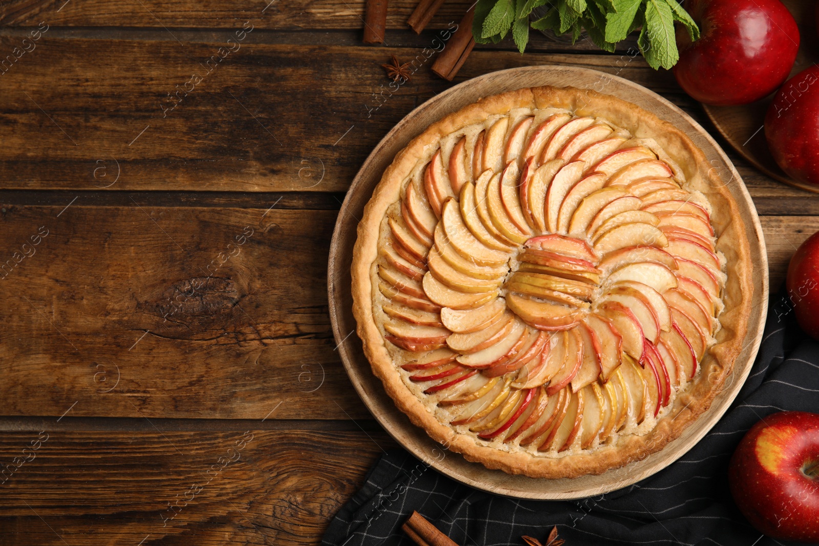 Photo of Flat lay composition with delicious homemade apple tart on wooden table. Space for text