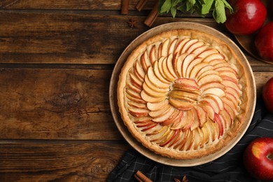 Flat lay composition with delicious homemade apple tart on wooden table. Space for text