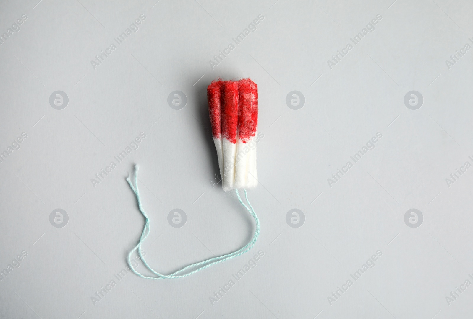 Photo of Used tampon on light grey background, top view