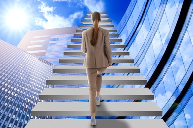 Image of Steps to success. Businesswoman climbing up stairs among buildings