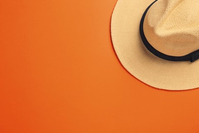 Photo of Stylish straw hat on orange background, top view. Space for text