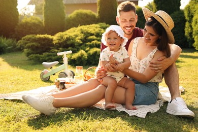 Photo of Happy family having picnic in garden on sunny day