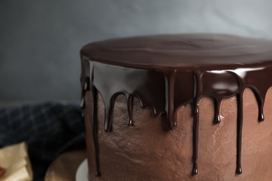 Photo of Freshly made delicious chocolate cake against grey background, closeup