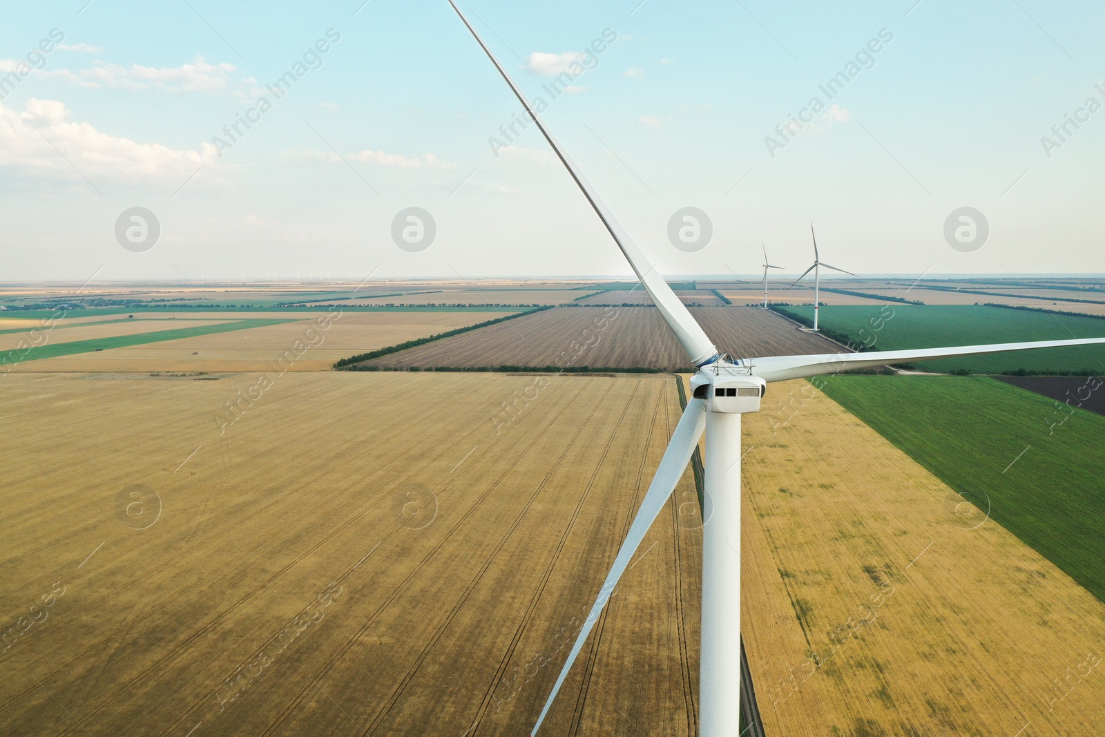 Photo of Modern windmill in wide field. Energy efficiency