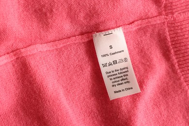 Photo of Clothing label on coral garment, top view