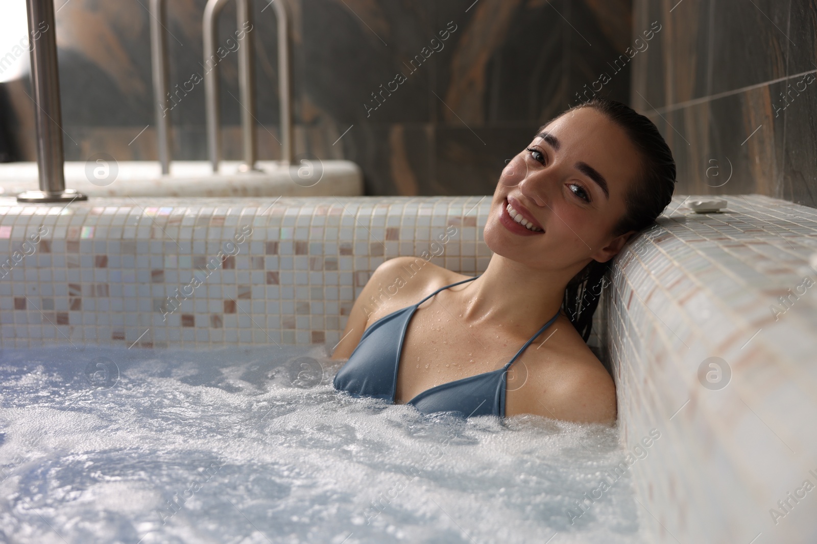 Photo of Beautiful woman relaxing in spa swimming pool, space for text