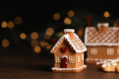 Photo of Beautiful gingerbread houses with icing on wooden table, space for text