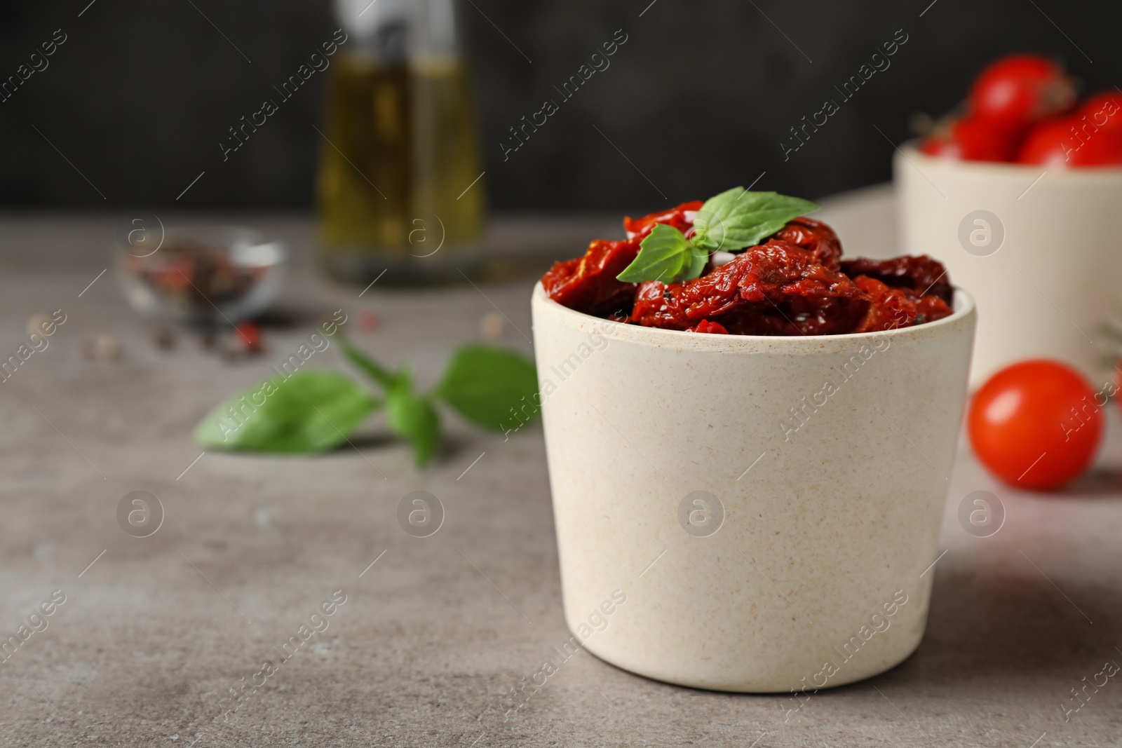 Photo of Bowl with sun dried tomatoes on gray table