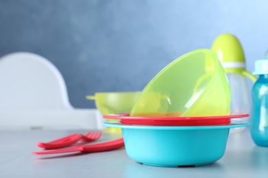 Photo of Bright child's dishware on grey table indoors. Space for text