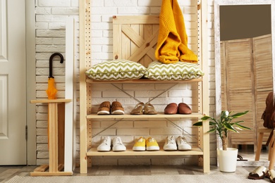 Photo of Cozy hallway interior with wooden shelving unit. Stylish design idea