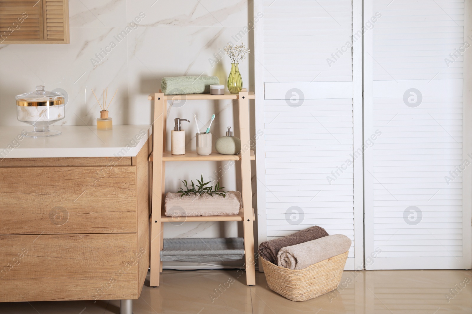 Photo of Shelving unit with toiletries in stylish bathroom interior 