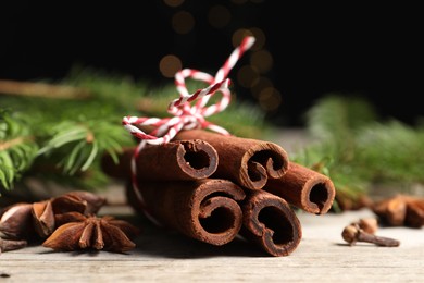 Different spices and fir branches on wooden table, closeup