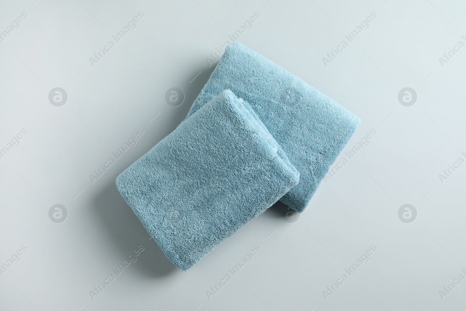 Photo of Fresh fluffy folded towels on grey background, top view. Mockup for design