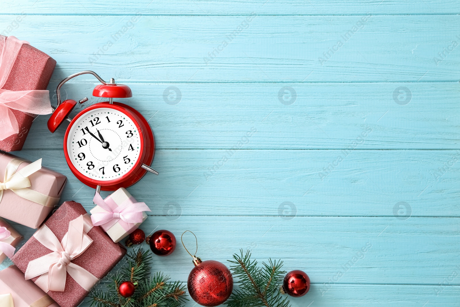 Photo of Flat lay composition with alarm clock and Christmas decor on light blue wooden background, space for text. New Year countdown
