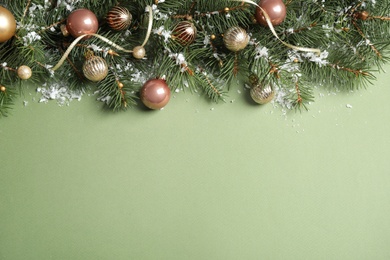 Fir tree branches with Christmas decoration on green background, flat lay. Space for text