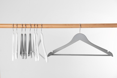 Photo of Wooden rack with clothes hangers on white background