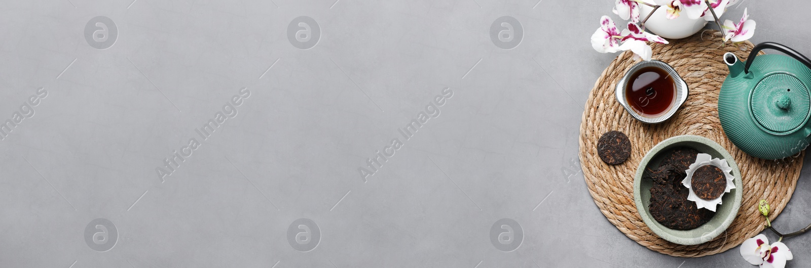 Image of Aromatic pu-erh tea served on grey table, top view. Banner design with space for text